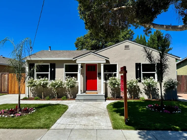 Taupe stucco bungalow with a red front door, white rose standards and a paver walkway at 131 Charles St, Sunnyvale, California
